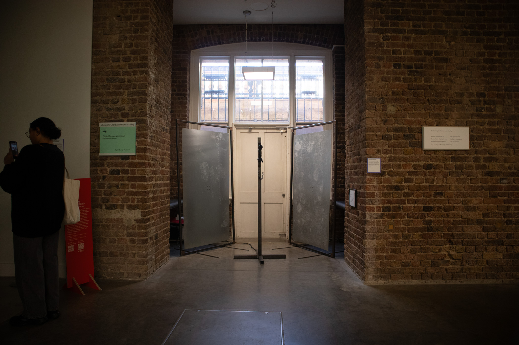 Phone on a metal pole with a red light ontop of it